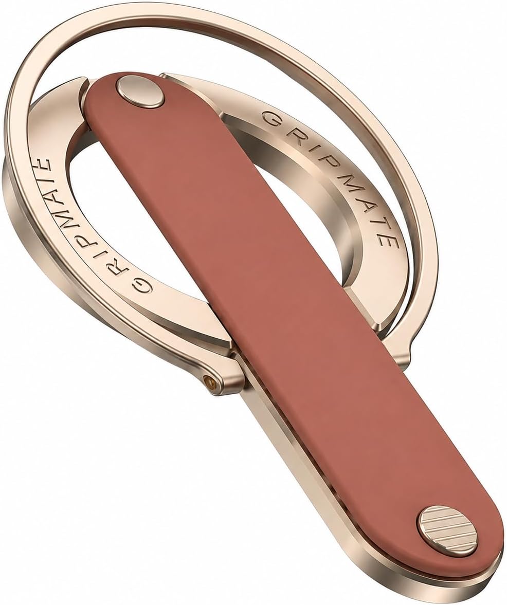 A close-up of a metallic keyring with a rose gold finish and a reddish-brown leather strap. The brand name 'GRIPMATE' is engraved on the metal.